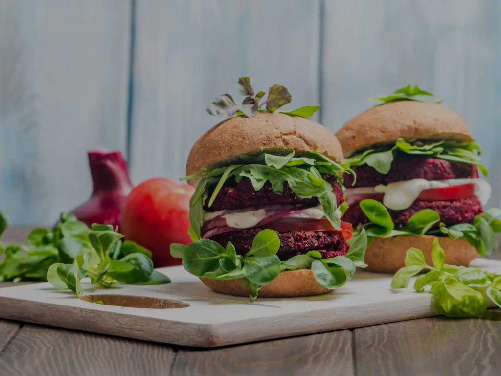 Plant-based meat burgers with herbs, tomatoes and red onions